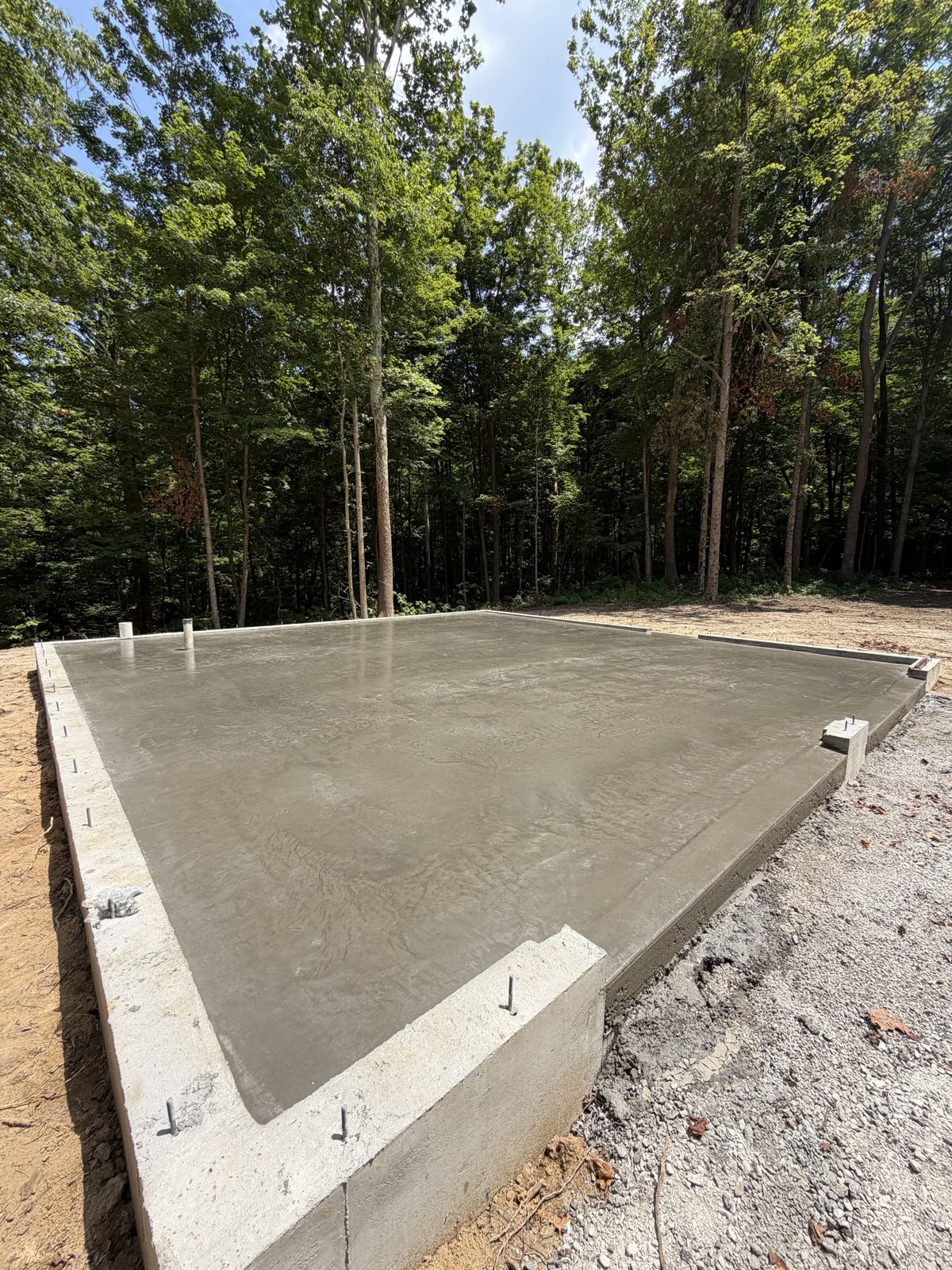 Finished poured concrete slab and foundation on a wooded lot